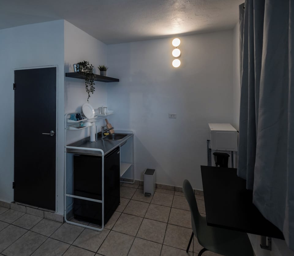 The kitchenette area features a refrigerator, microwave, and coffee maker.