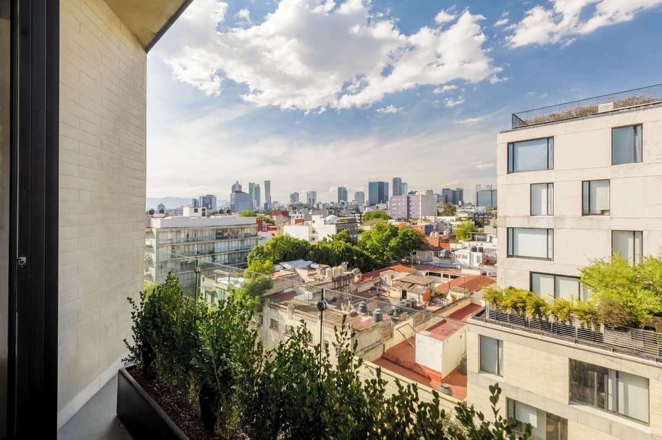 Balcony with panoramic city views and surrounding buildings.