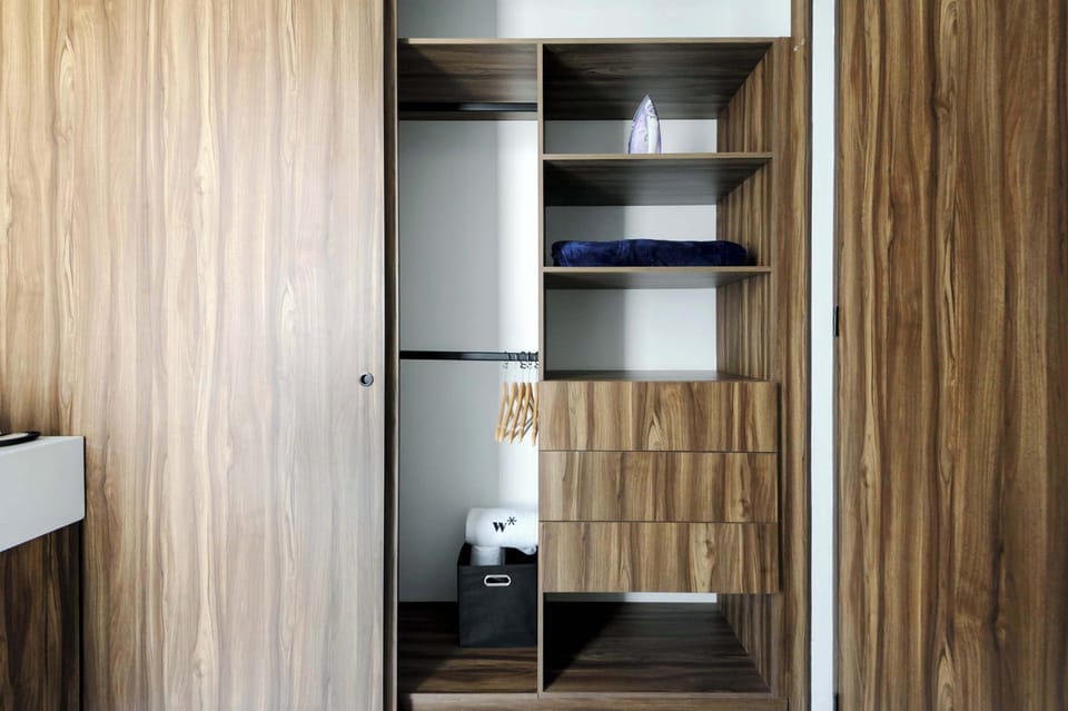 Spacious walk-in closet with wooden shelves and doors.