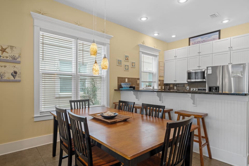 Dining area with 6 seats at the table and 3 stools at the bar