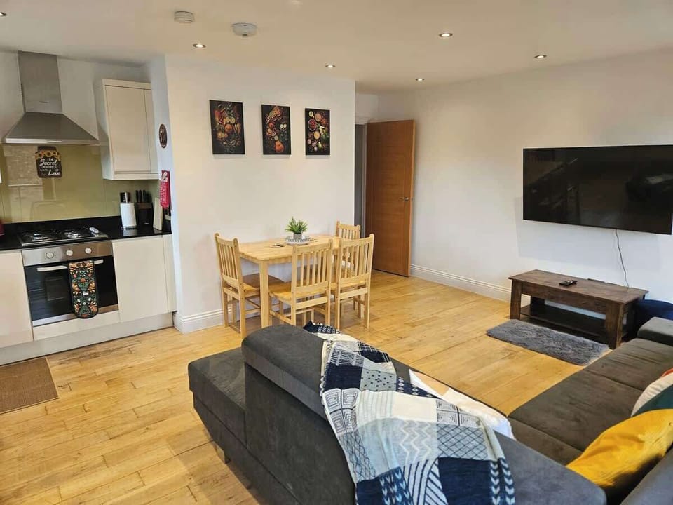 Spacious, sun-filled living area with corner sofa bed, dining table and balcony access — ideal for relaxing together. Includes TV with Netflix and a fully equipped kitchen.
