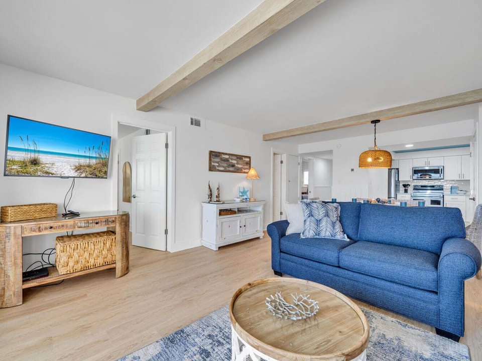 Sink into this coastal-inspired living room where beach blues meet warm woods, creating your perfect oceanside retreat.