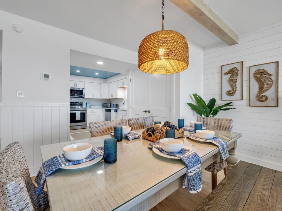 Your coastal dining space radiates warmth with woven lighting and nautical touches, creating perfect moments for memorable meals together.