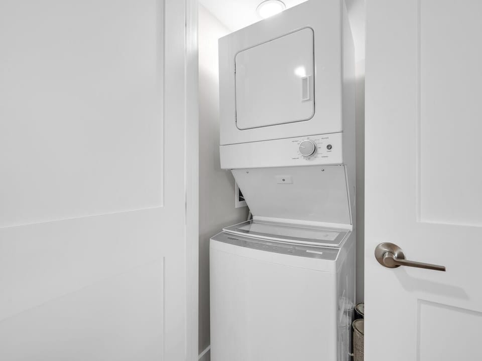Keep your wardrobe fresh with convenient in-unit laundry facilities, featuring a stacked washer and dryer in a dedicated closet space.