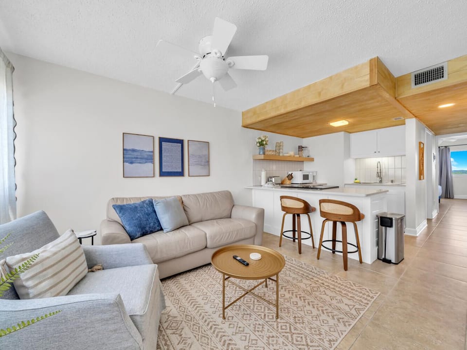 Unwind in your bright, modern living space with plush seating and stylish kitchen bar perfect for morning coffee or evening conversations.