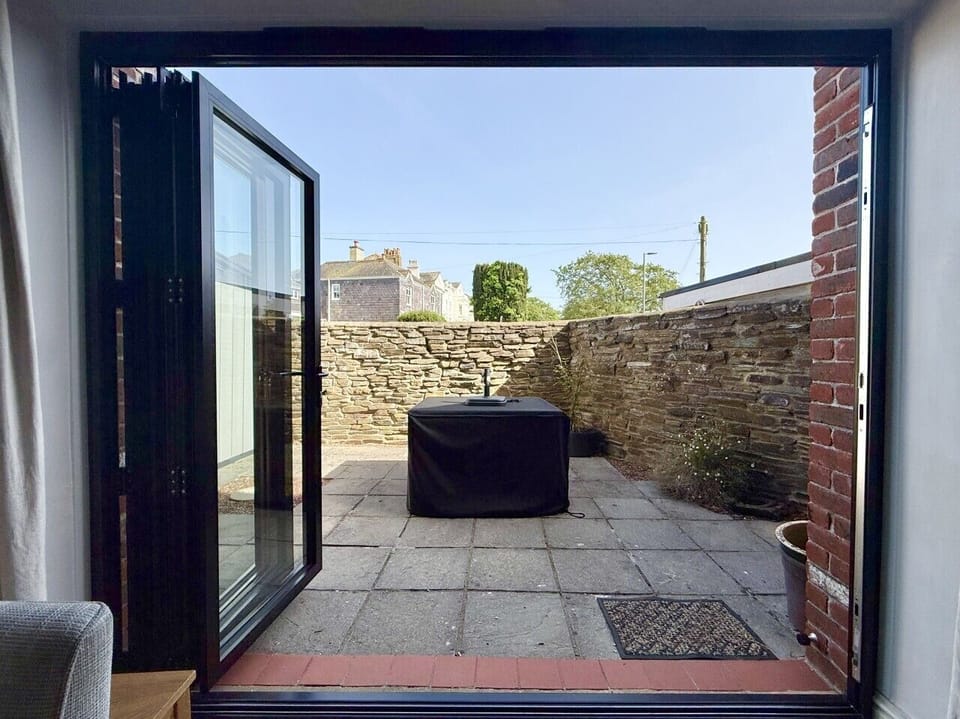 New bifold doors with access to courtyard garden with dining table and chairs