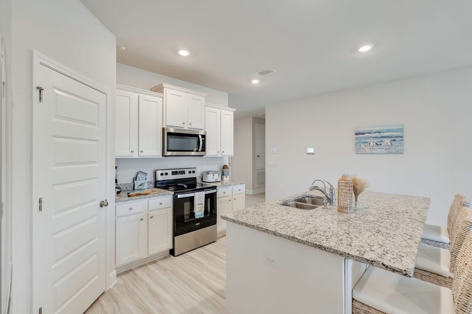 Your fully equipped kitchen features granite counters, stainless appliances, and coastal touches that make meal prep a pleasure.