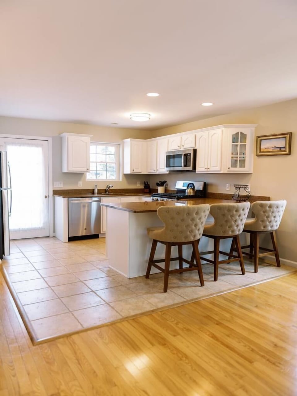 Bright and open kitchen with bar seating, stainless appliances, and plenty of counter space.