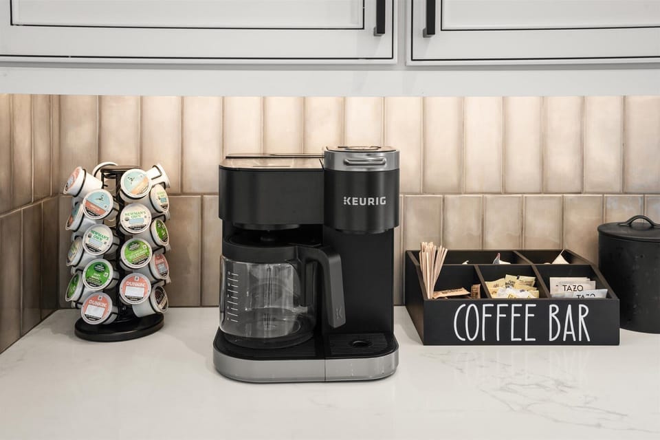 Coffee station setup with coffee maker and accessories in a modern kitchen.
