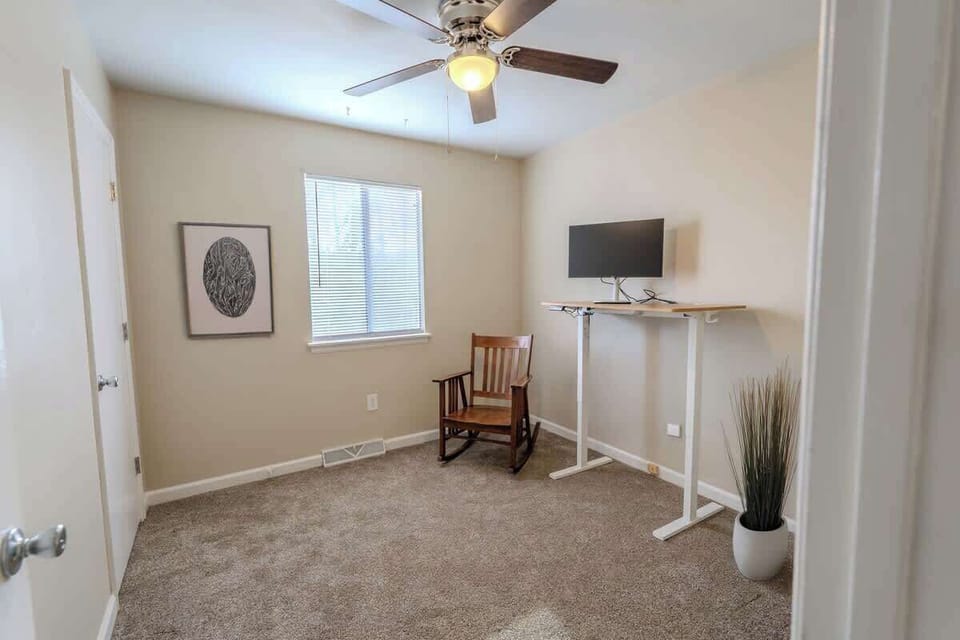 Office space with standing desk and ceiling fan
