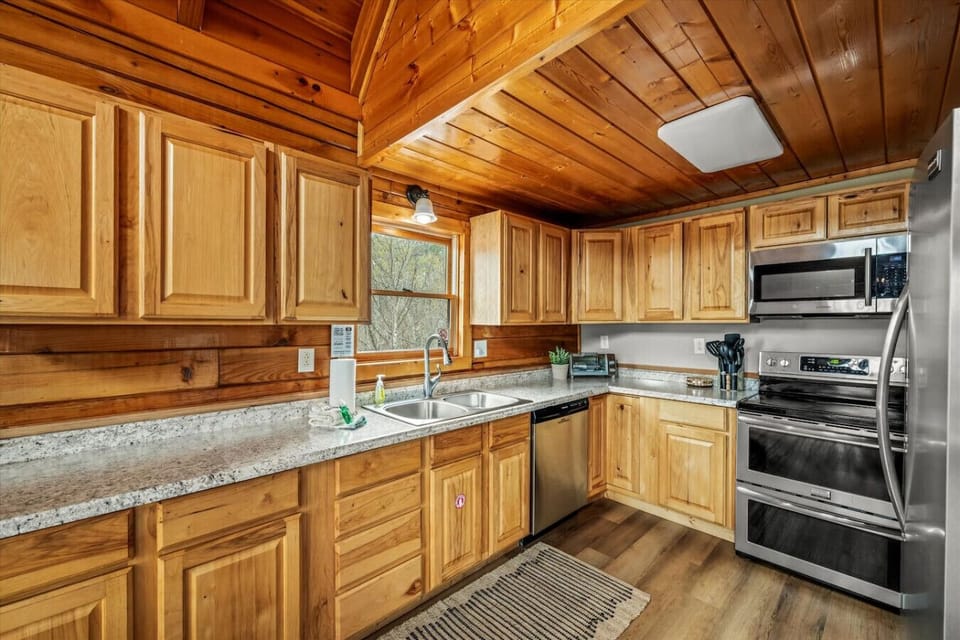 Spacious countertops, custom wood cabinets, and warm natural light make this kitchen both functional and inviting.