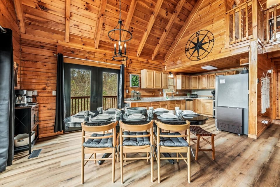 Gather around the large dining table, set for eight, and enjoy a meal surrounded by cabin charm and forest views.