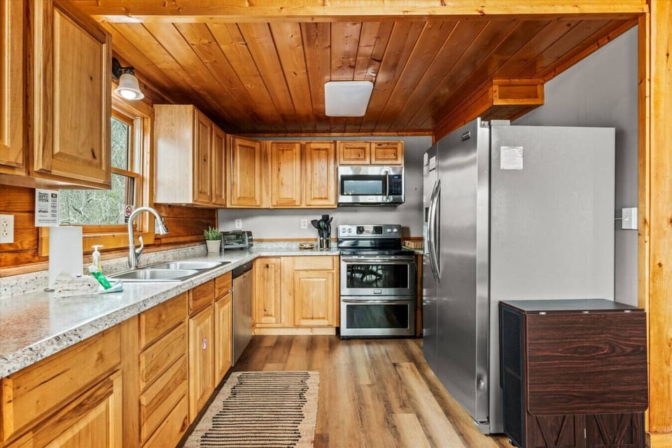 This fully equipped kitchen blends rustic charm with modern convenience, featuring stainless appliances and everything you need to cook up a feast.