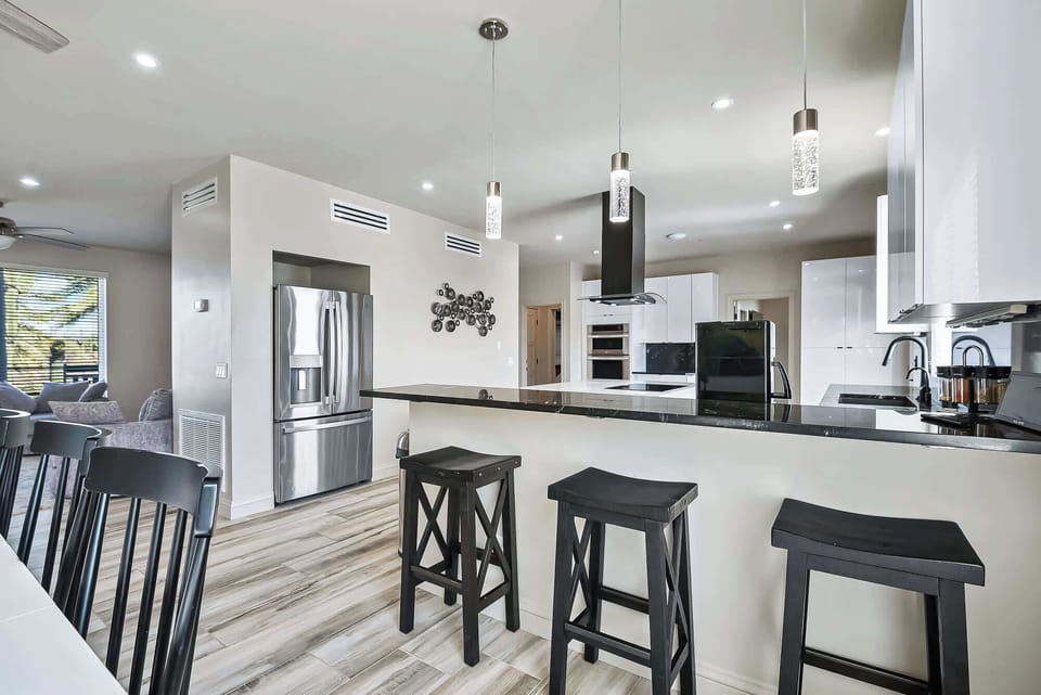"Enjoy casual dining and lively conversations at our chic kitchen bar, where comfort meets convenience."
