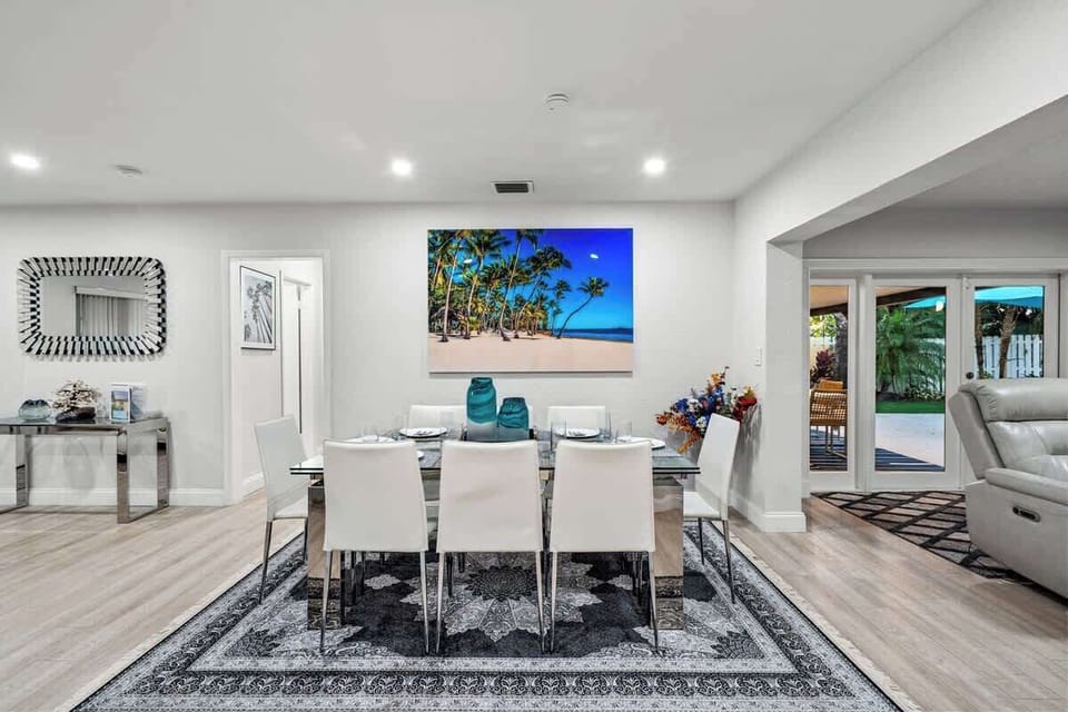 Dining table for six under artwork, with the patio doors beyond.
