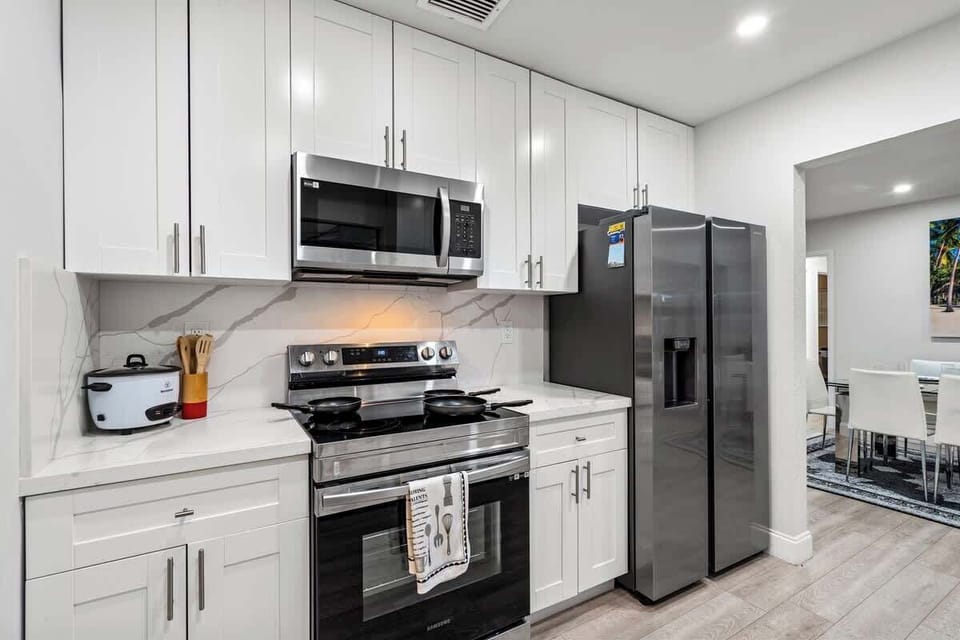Kitchen with electric range, microwave and large fridge freezer.