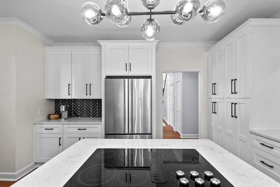 A large, airy, white kitchen with modern appliances and a clean, modern look. This kitchen is loafed with all the essentials to get you started on your next culinary adventure.