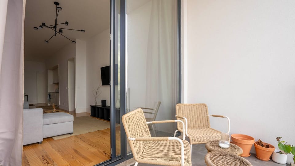 Step outside to this cozy balcony space, seamlessly connected to the living area. Perfect for a morning coffee or a peaceful evening in Porto. 🌿☕ #PortoRetreat #BalconyVibes #RelaxInPortugal