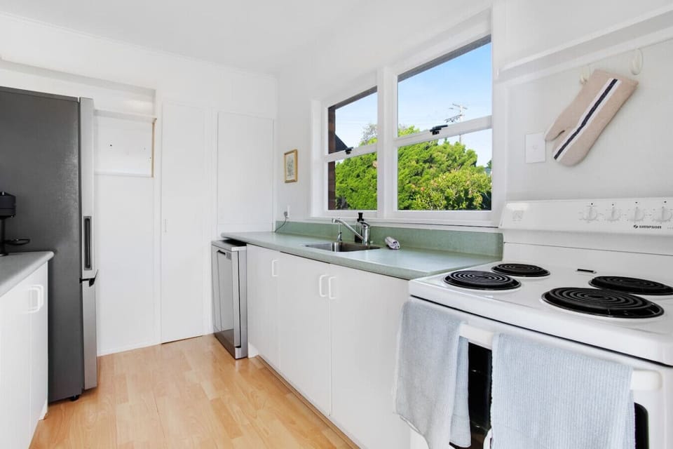 The kitchen has an oven, cooktop, dishwasher, microwave and fridge/freezer.