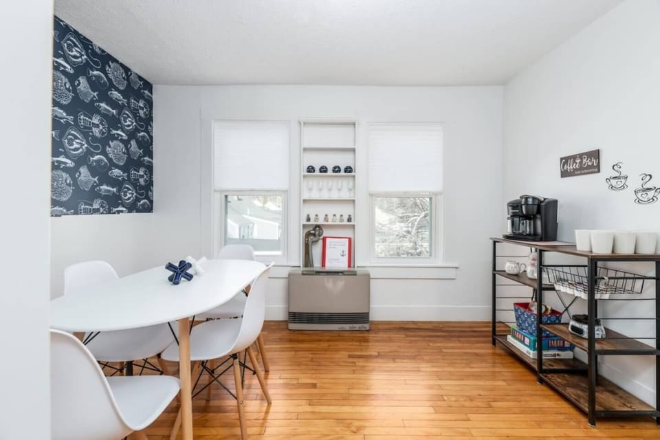 Bright dining area featuring gleaming hardwood floors and a modern table for four. Includes a dedicated coffee station—perfect for starting your mornings before heading to the beach