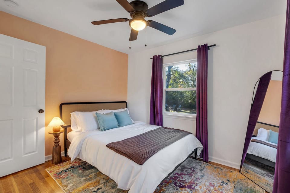 Bedroom with plush queen bed and standing mirror