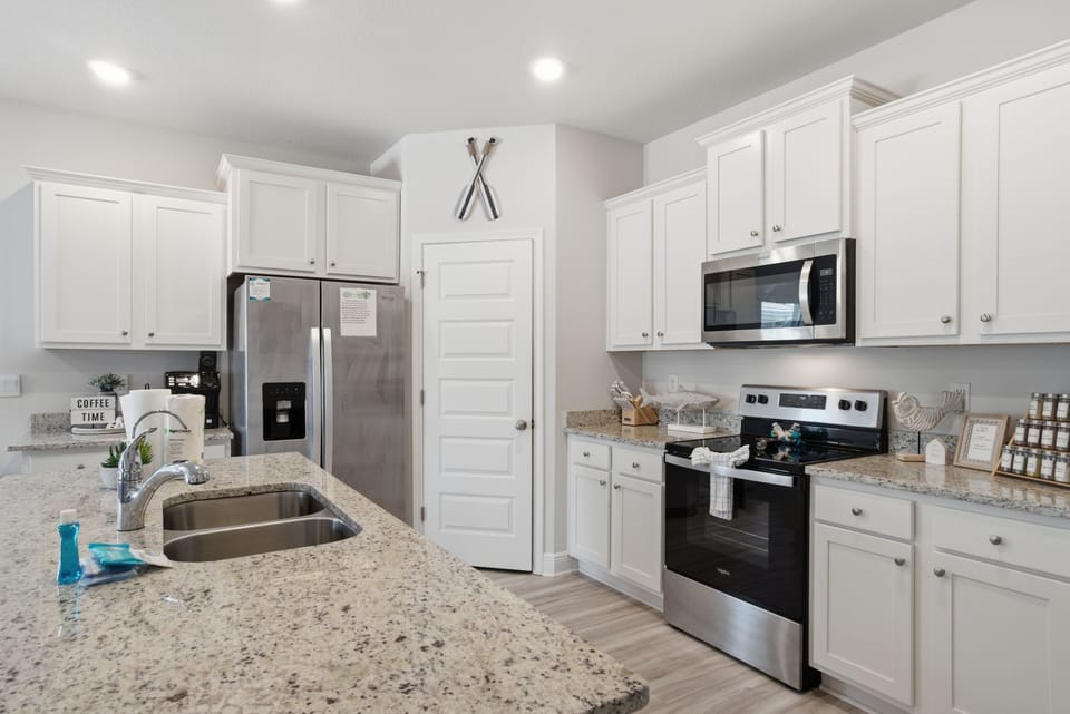 Your bright, fully-equipped kitchen awaits with granite counters, stainless appliances, and all the essentials for preparing memorable meals together.