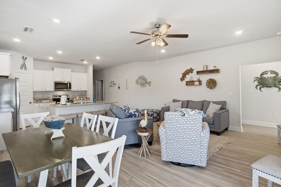 Relax in your bright, coastal-themed living space with comfy seating, full kitchen, and beachy décor perfect for unwinding.
