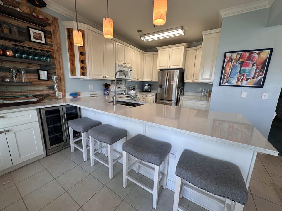 Fully equipped kitchen with a large breakfast bar and seating for four.