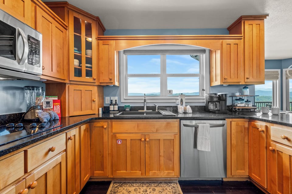 Range, microwave, dishwasher, and a view over the sink