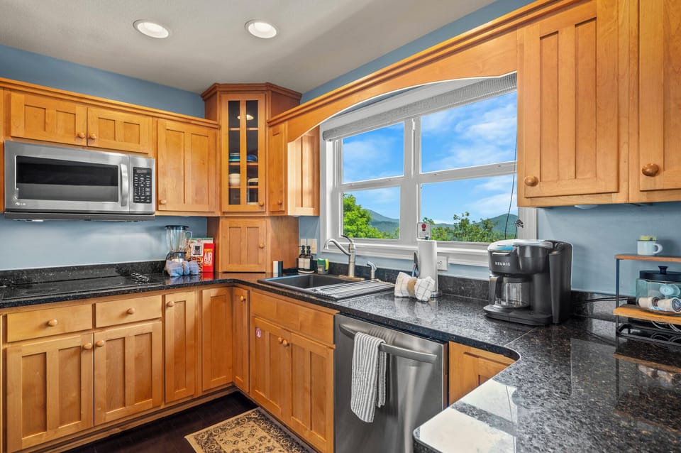 Granite counters and a kitchen window aimed at the mountains
