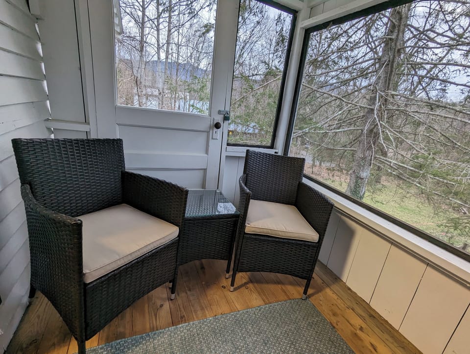 Semi enclosed/screened in back porch overlooking the backyard & creek