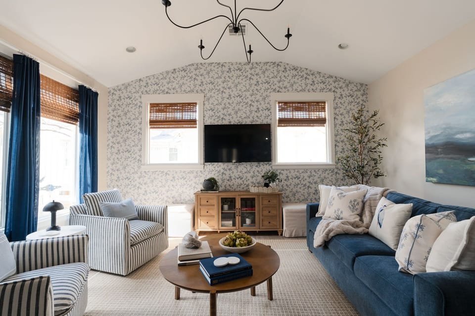 Living space with queen sleeper sofa, 2 swivel chairs, and a set of ottomans