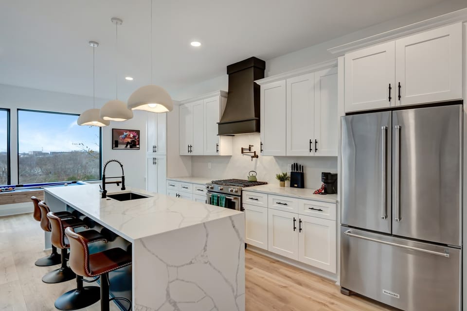 Experience this luxurious kitchen, ideal for cooking or hosting a bachelorette party! With sleek countertops and an open layout, enjoy skyline views as you prepare meals in the heart of Nashville. Your unforgettable vacation home awaits!