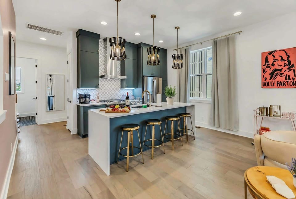 Cook together in a kitchen built for groups: the dark green island and open countertops mean the whole crew stays connected while prepping a meal
