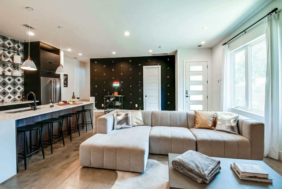 Gather 20 friends in an open living room where the bar cart is always ready and the sectional pulls everyone together. Book your group getaway with Misfit Homes near The Gulch in Nashville