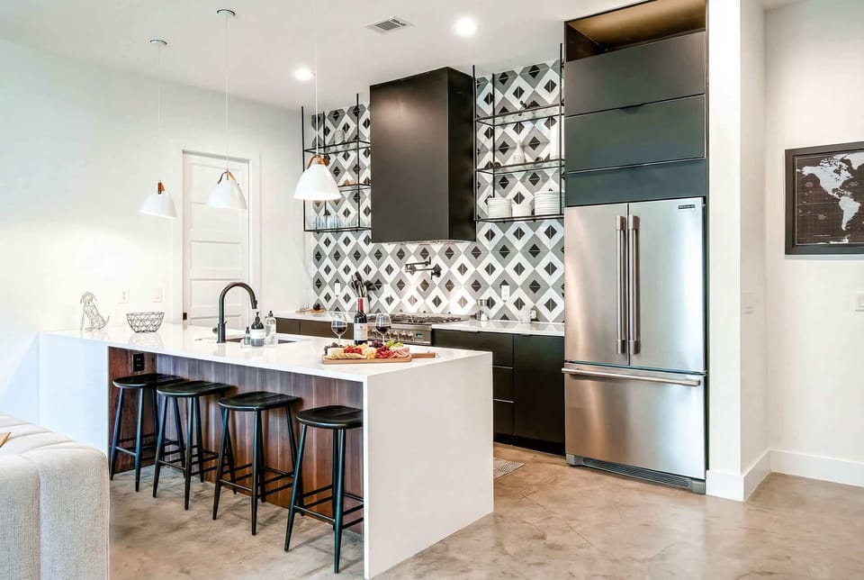 Gas stove, full-size fridge, bar seating for eight. Both kitchens are built to handle a real dinner party without anyone standing in the hallway