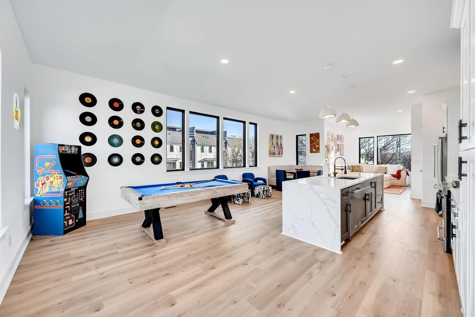 Kitchen island opens directly into the game room, making it easy to grab snacks mid-pool-table rematch or transition from cooking to arcade rounds
