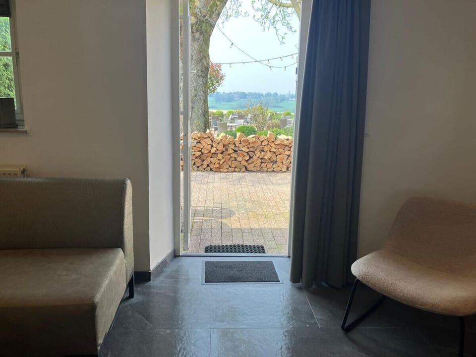 Uitzicht vanuit woonkamer op terras en vallei