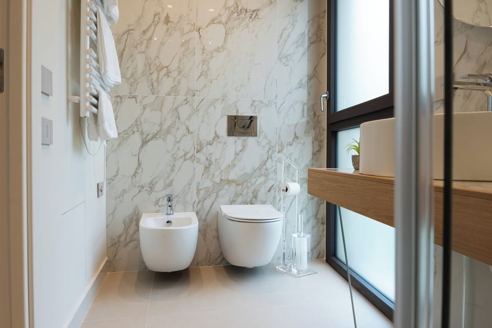 Design Suite, Partial Sea View | Bathroom | Shower, hair dryer, slippers, bidet