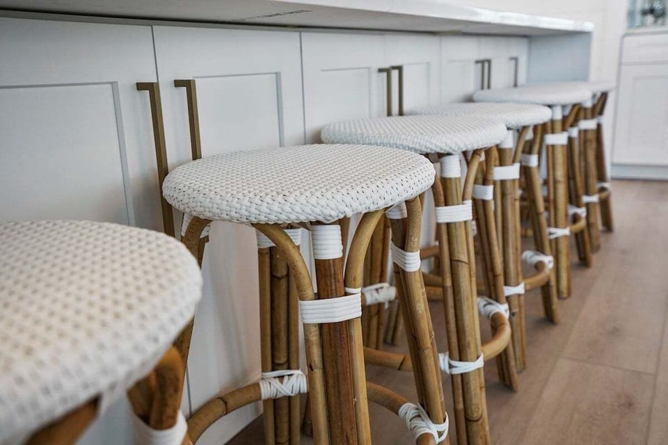 enjoy conversation on this row of stylish barstools with woven seats and rattan frames plus  inviting atmosphere at the kitchen counter.