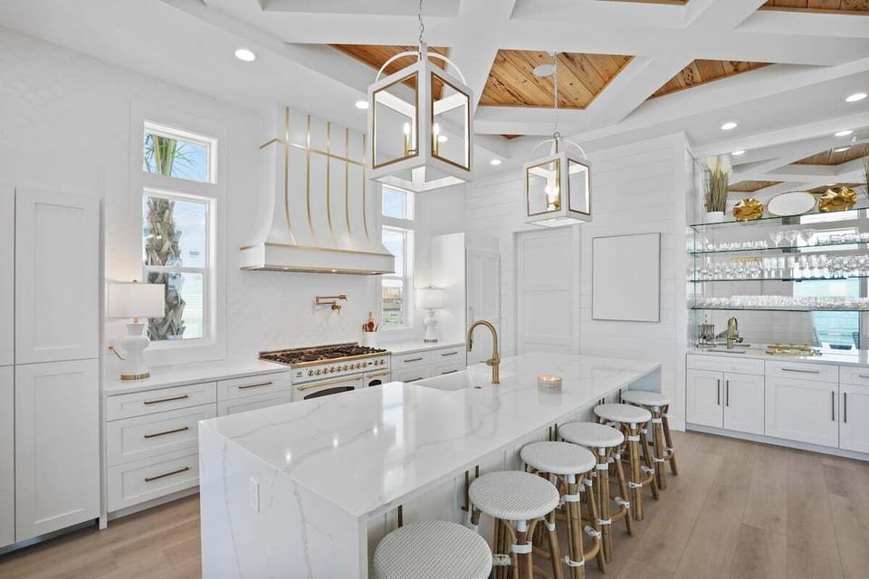This spacious kitchen features a large island with seating, high ceilings with a coffered design, and a professional-grade range perfect for culinary adventures