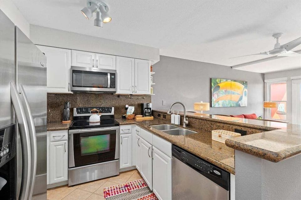 Fully equipped kitchen with stainless steel appliances, granite countertops, and ample cabinet storage.