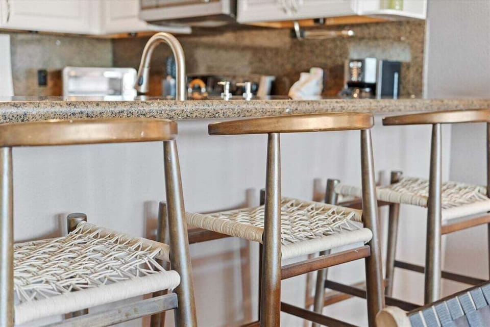 Breakfast bar with seating and granite countertops ideal for casual dining, coffee, or meal prep.