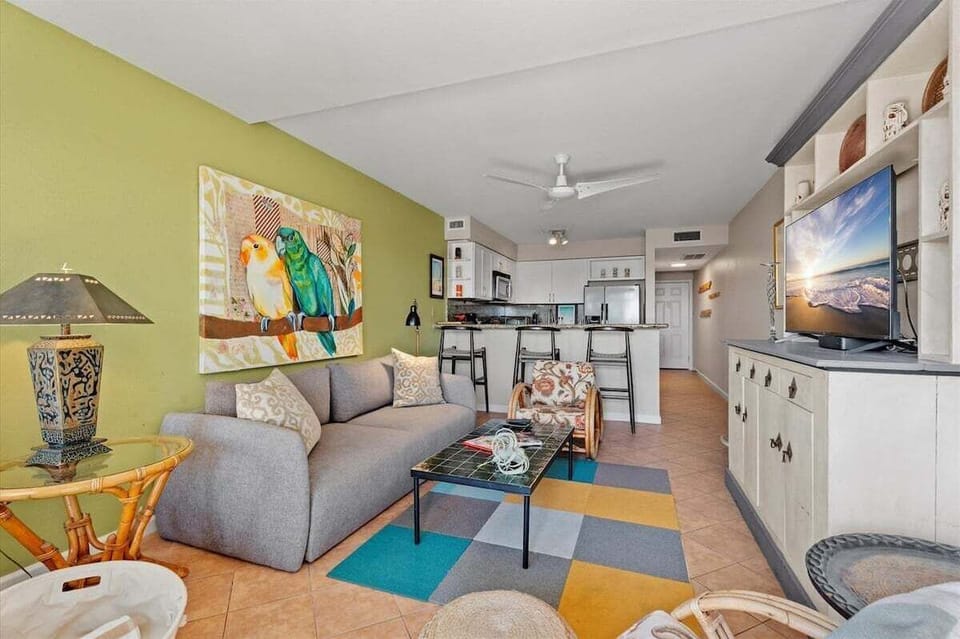 Spacious living room and kitchen layout with comfortable seating, granite breakfast bar, and an inviting open floor plan.
