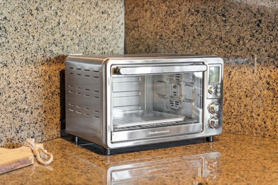 Countertop toaster oven on granite counter, convenient small appliance for easy vacation meals.