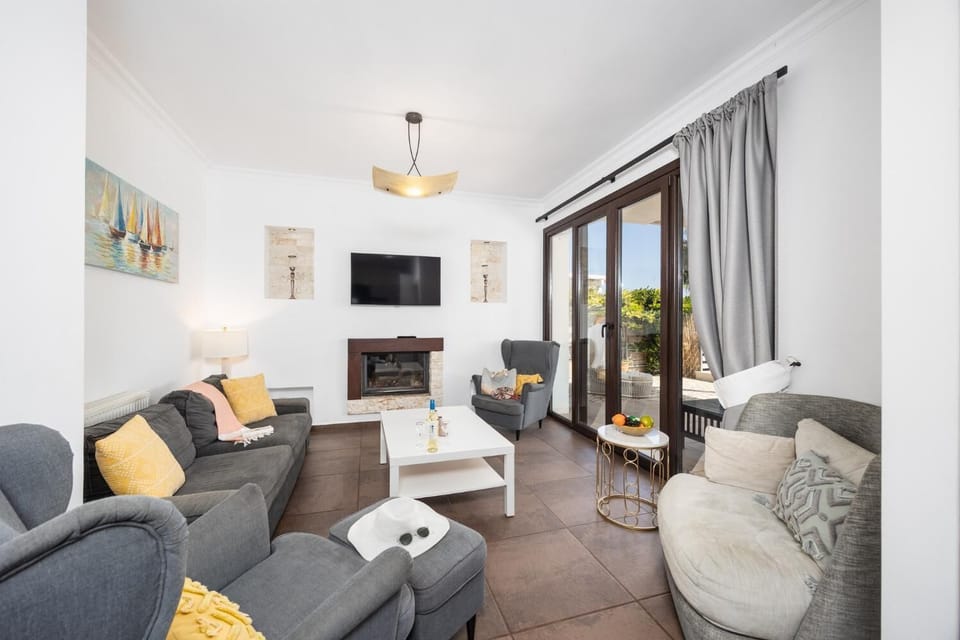 Living room with sofa, ornamental fireplace, A/C, WiFi internet, and satellite TV