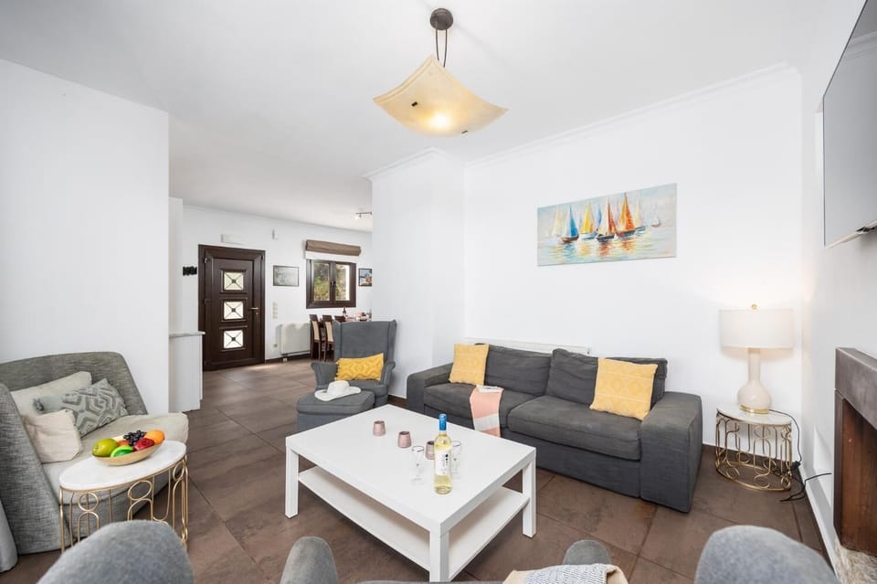 Living room with sofa, ornamental fireplace, A/C, WiFi internet, and satellite TV