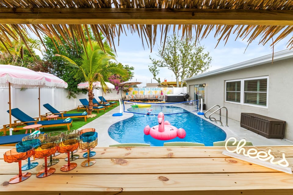 Experience paradise at home with this breathtaking pool and tiki bar retreat.