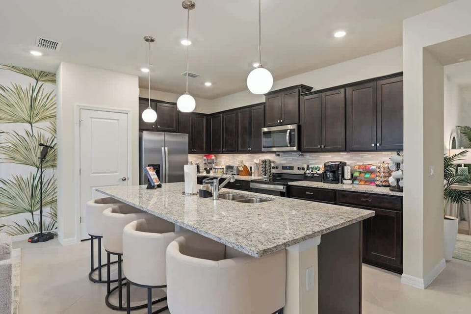 Gourmet kitchen with rich cabinetry and stainless appliances, fully stocked coffee bar and popcorn maker. Granite island with breakfast bar. Stainless steel gas range. Extra dinnerware, silverware and cookware included.