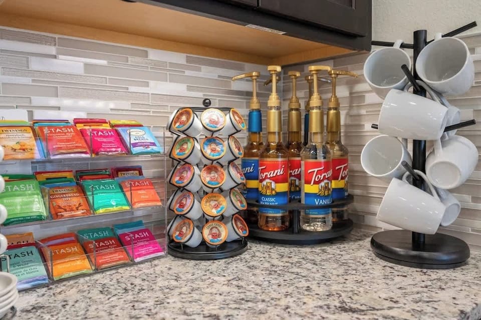 Fully stocked coffee bar with coffee and tea essentials, including an array of k-cups, and teas, sweeteners, and more. 